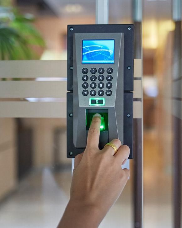 Woman pressing finger onto fingerprint scanner in access control system