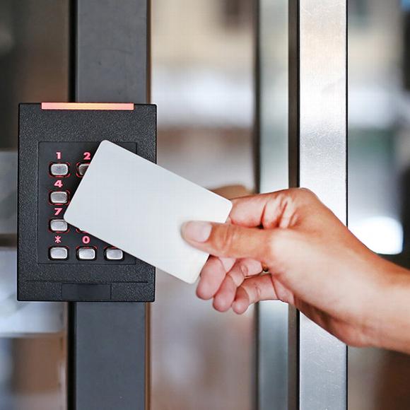 Woman tapping access card to security system on door