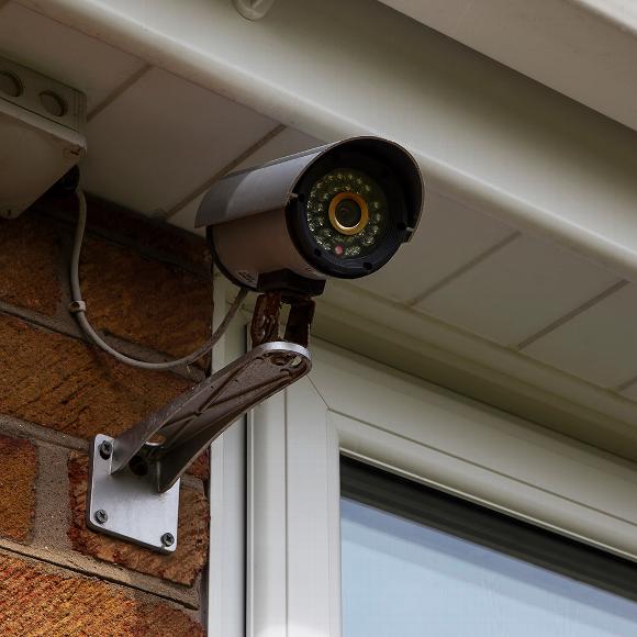 Black cctv camera installed onto outside of residential home