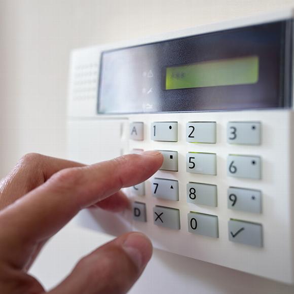 Hand pressing buttons on intruder alarm system